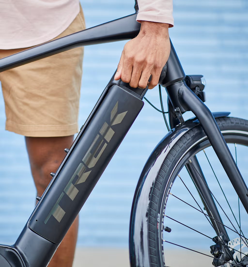 Rider lifting a Trek e-bike with a removable battery