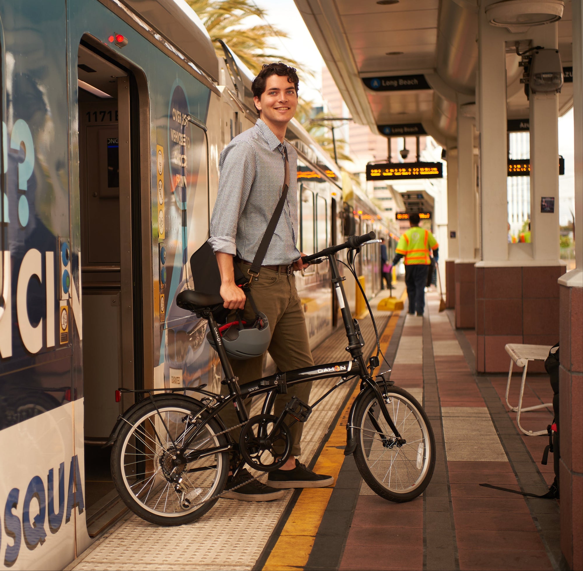 Commuter stepping off a train platform with a DAHON folding bike