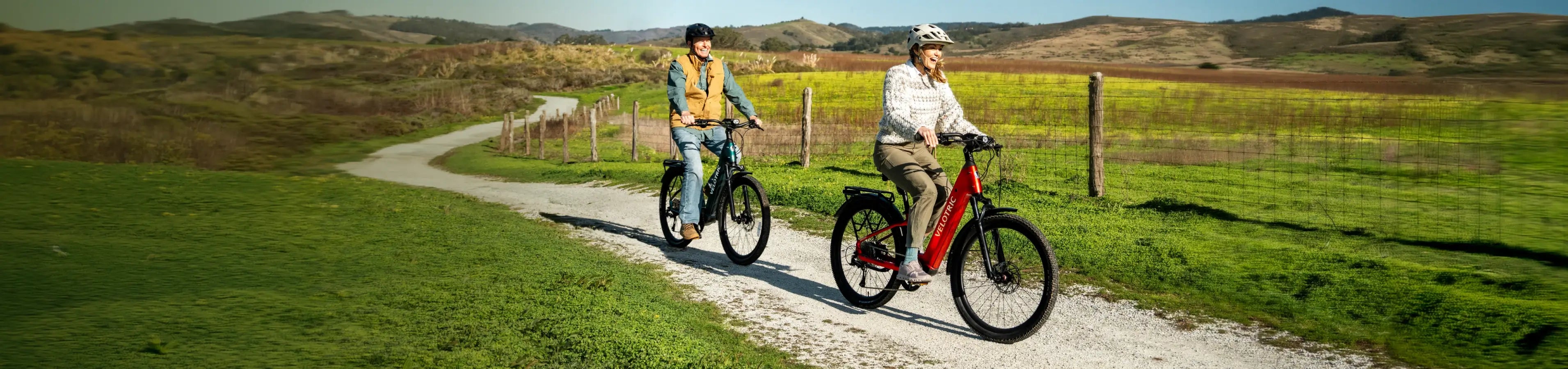 Two riders on Velotric Discover 3 e-bikes on a gravel path